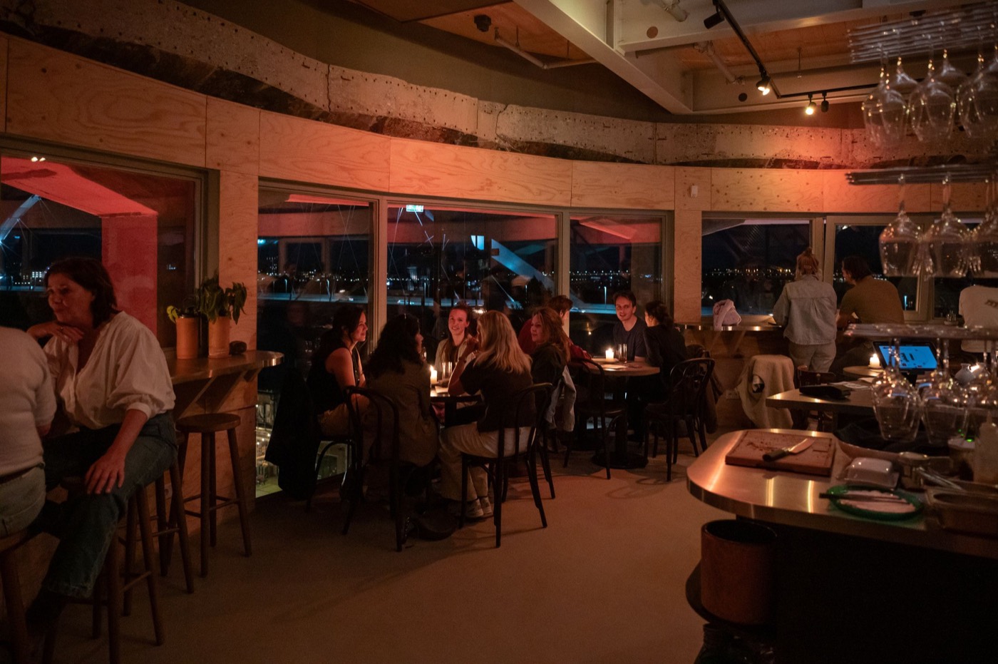 De panoramabar in de avond, met gasten aan tafels bij kaarslicht