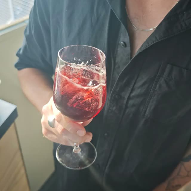 Een rood drankje met ijs in een wijnglas